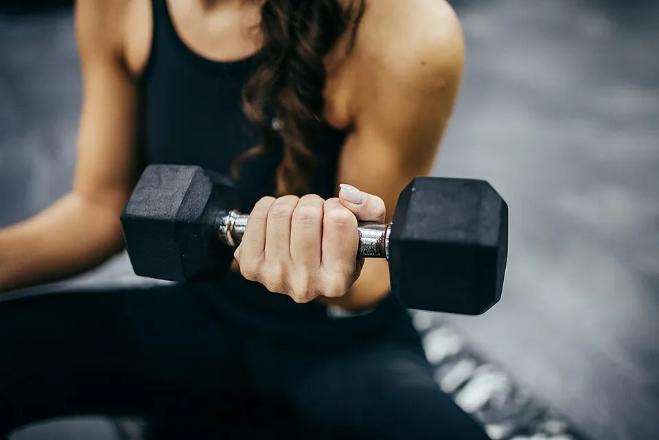 Close-up of a woman's hand doing a bicep curl with a dumbbell